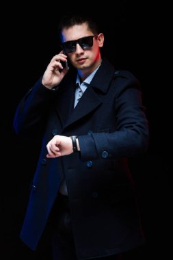 Smartphone üzerinde konuşmak ve zaman kontrol genç yakışıklı adam 