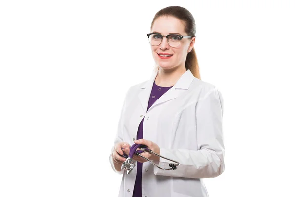 年轻的女医生与听诊器微笑在相机在白色背景下隔离 — 图库照片