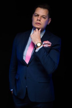 Kameraya bakarak onun çene üzerinde el ile takım elbiseli genç yakışıklı adam 