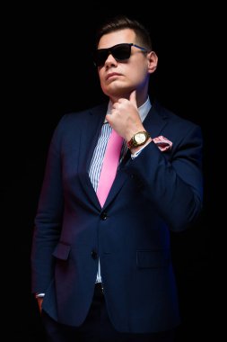 Siyah arka plan üzerine şık güneş gözlüklü genç trendy adam 