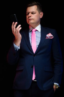 Genç yakışıklı adam akıllı telefon tutarak ve bakmak 