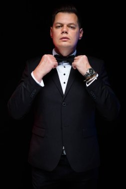 Onun papyon ayarlama takım elbiseli genç yakışıklı adam 