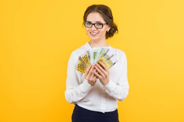 Euro banknot sarı stüdyo arka planda tutan genç esmer kadın 