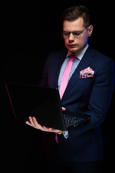 Ung Vacker Man Arbetar Laptop Mot Mörka Studio Bakgrund — Stockfoto