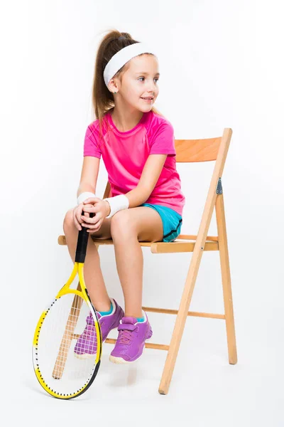 可爱的小女孩坐在椅子和举行壁球球拍 — 图库照片