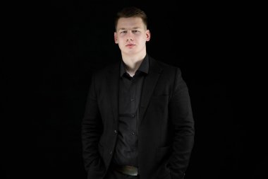 Siyah takım elbise giyen ve kameraya poz emin sarışın yakışıklı olan