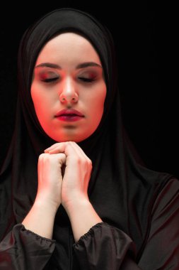 Geleneksel giysiler içinde dua eden genç Müslüman kadın portresi