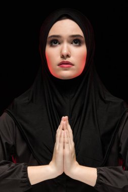 Geleneksel giysiler içinde dua eden genç Müslüman kadın portresi