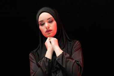 Geleneksel giysiler içinde dua eden genç Müslüman kadın portresi