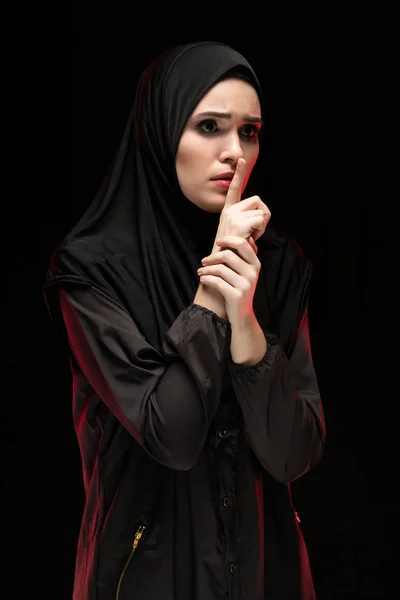 portrait of young Muslim woman covering mouth by finger, keep silent concept