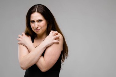 Studio gri duvar farklı ifadeler gösterilen basit siyah gömlekli uzun lüks saçlı güzel curvy esmer kadın. Bu gibi elleri geçiş soğuktur.