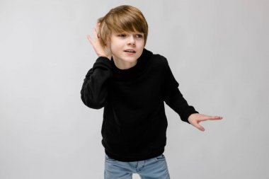 Sevimli beyaz çocuk Studio beyaz duvar üzerinde farklı ifadeler gösterilen siyah kıyafeti.