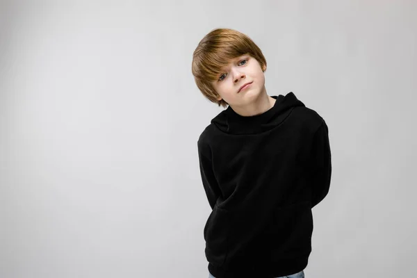 スタジオで白い壁に表情を示す黒の服でかわいい白人少年 — ストック写真