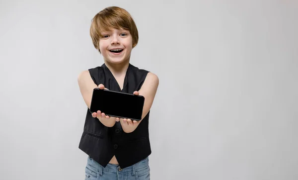 Bonito Caucasiano Menino Preto Roupa Mostrando Diferentes Expressões Segurando Smartphone — Fotografia de Stock