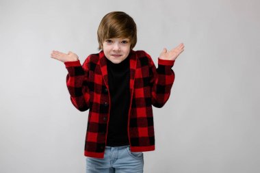 Gündelik kıyafeti Studio beyaz duvar üzerinde farklı ifadeler gösterilen iyi preteen beyaz çocuk. Elleri ile suçlu tebessüm kusuyor.