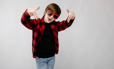 İyi preteen beyaz çocuk rahat kıyafet Studio beyaz duvar komik güneş gözlüğü farklı ifadeleri ile poz.