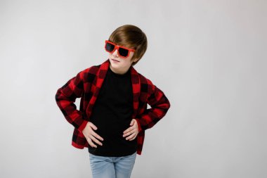 İyi preteen beyaz çocuk rahat kıyafet Studio beyaz duvar komik güneş gözlüğü farklı ifadeleri ile poz.