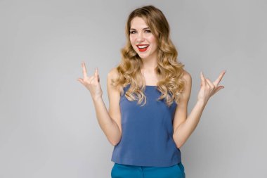 Çekici genç Beyaz sarışın kadın rahat kıyafet Studio gri duvar farklı ifadeler gösterilen. 