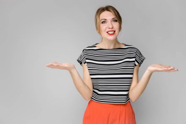 Çekici genç Beyaz sarışın kadın rahat kıyafet Studio gri duvar farklı ifadeler gösterilen. 