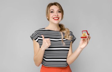 Çekici genç Beyaz sarışın kadın stüdyo ışık arka plan üzerinde kırmızı hediye kutusunda mutluluk ifadesi ile bitcoin ile poz.
