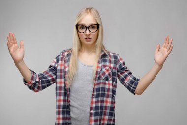 Kareli gömlek ve gri duvar Studio farklı duygusal ifadeler gösterilen gözlük oldukça Beyaz sarışın genç kız.