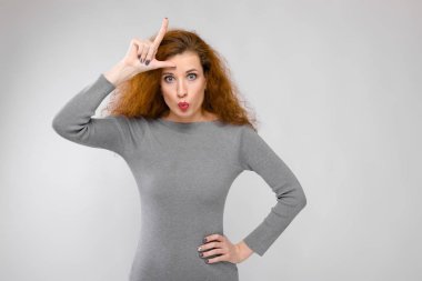 Güzel kıvırcık saçlı Kafkas kadın gri elbise farklı duygusal ifadeler Studio beyaz duvar üzerinde gösterilen.