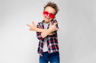 Güzel beyaz okul öncesi çocuk rahat kıyafet ve beyaz duvar Studio farklı ifadeler gösterilen kırmızı güneş gözlüğü.