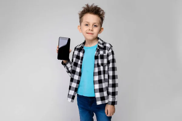 漂亮的学前儿童白种男孩穿着休闲装与智能手机显示不同的表达式在演播室白墙 — 图库照片