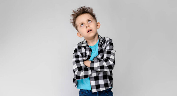 Nice caucasian preschooler boy in casual outfit showing different expressions on white wall in studio. 