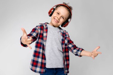 Güzel beyaz okul öncesi çocuk kırmızı kulaklık ile poz ve beyaz duvar Studio farklı ifadeler gösterilen gündelik kıyafeti.