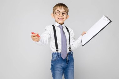 Çok güzel ciddi emin küçük çocuk Pano gri arka plan üzerinde tutarak bardaklarda portresi