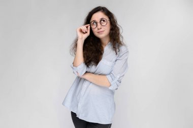 Çekici genç kıvırcık esmer beyaz kadın gri izole gözlük