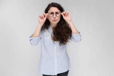 Çekici genç kıvırcık esmer beyaz kadın gri izole gözlük