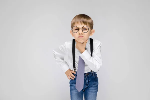 在灰色背景下戴眼镜的可爱严肃自信的小男孩肖像 — 图库照片