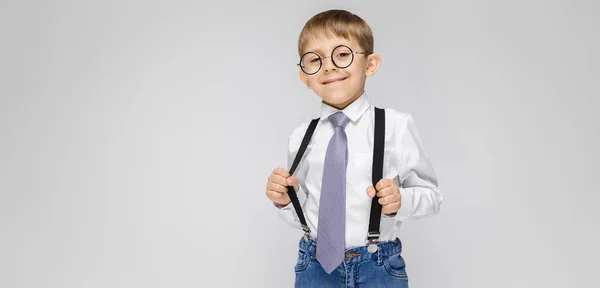 在灰色背景下戴眼镜的可爱严肃自信的小男孩肖像 — 图库照片