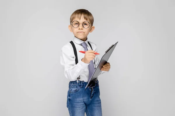 Retrato Adorable Niño Confiado Serio Gafas Sujetando Portapapeles Sobre Fondo — Foto de Stock