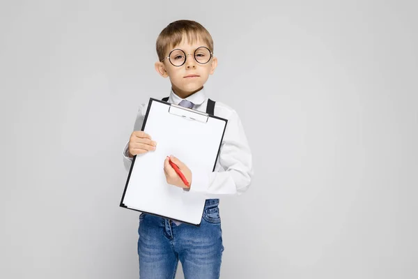 Retrato Adorable Niño Confiado Serio Gafas Sujetando Portapapeles Sobre Fondo — Foto de Stock