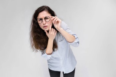 Çekici genç kıvırcık esmer beyaz kadın gri izole gözlük