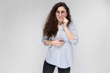 Çekici genç kıvırcık esmer beyaz kadın gri izole gözlük