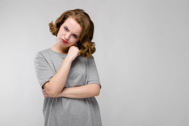 Gri arka plan üzerinde yapması güzel kızıl saçlı mutlu genç kadın portresi