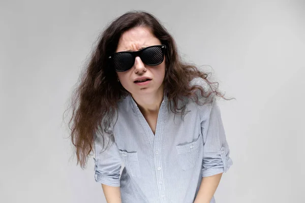 Joven Morena Rizada Mujer Caucásica Probando Gafas Estenopeicas Aisladas Gris —  Fotos de Stock