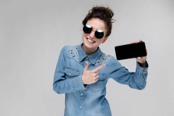 Joven Morena Caucásica Con Peinado Moño Gafas Sol Mostrando Smartphone —  Fotos de Stock