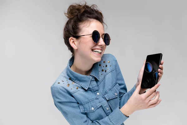Jonge Brunette Kaukasische Meisje Met Bun Kapsel Zonnebril Toont Smartphone — Stockfoto