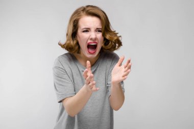 Gri arka plan üzerinde yapması güzel kızıl saçlı mutlu genç kadın portresi