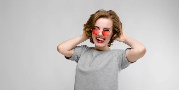 Szürke Háttér Piros Napszemüveg Gyönyörű Vörös Hajú Boldog Fiatal Portréja — Stock Fotó