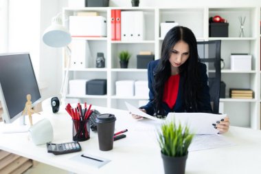 Güzel genç kız belgesiyle, office masada oturan arıyor.