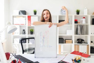 Ofiste güzel bir genç kız elini manyetik tahtaya tablo yakınındaki duruyor, pembe bir işaretleyici ağzına tutar ve bir kas gösterir