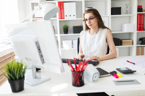 Молодая девушка сидит за рабочим столом в офисе и клавиатуре . — стоковое фото