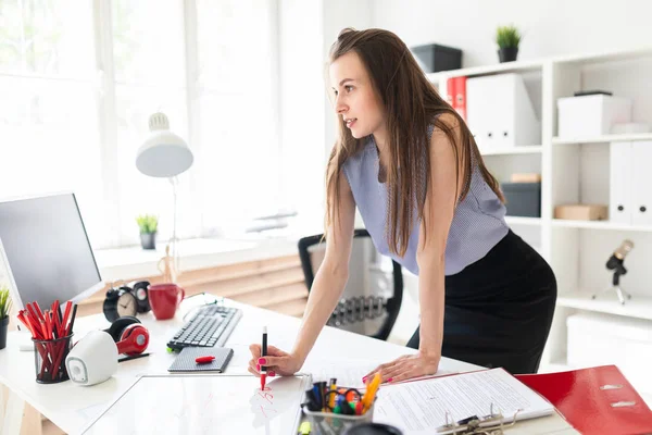 Mooi jong meisje in een kantoor is staande in de buurt van een tabel en een marker is geïnspireerd op een magneetbord. — Stockfoto