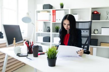 Güzel genç kız belgesiyle, office masada oturan arıyor.